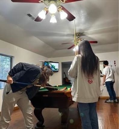 techie members gathered around a pool table